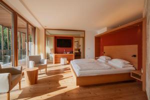 a bedroom with a large bed and a television at Hotel Der Waldhof in Vollan +78 photos