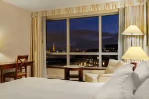 a hotel room with a bed and a large window at Occidental Paris Levallois in Levallois-Perret