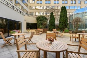 a patio with tables and chairs and a building at Occidental Paris Levallois in Levallois-Perret +45 photos