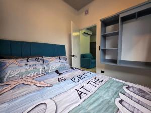 a bedroom with a large bed with a blue headboard at Ocean Breeze at Life's a Beach in Uvita +19 photos