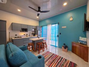 a living room with a blue couch and a kitchen at Ocean Breeze at Life's a Beach in Uvita