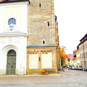 a building with a large tower on a street at Ferienwohnung 1 Christiansdorf Freiberg in Freiberg