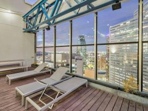 a balcony with two chairs and a view of a city at Luxury Apt W/Parking CityView|Pool| Gym|PoolTable in Dallas