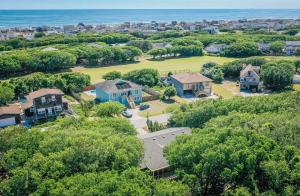 an aerial view of a home with trees and the ocean at Seascape Cottage - Kitty Hawk, MP 3.5, 300 Yds to Beach, Pool, Foosball, Near Golf Course, Flex Stays in Kitty Hawk