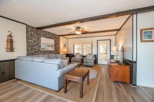 a living room with a couch and a table at Seascape Cottage - Kitty Hawk, MP 3.5, 300 Yds to Beach, Pool, Foosball, Near Golf Course, Flex Stays in Kitty Hawk