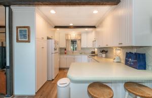 a kitchen with white cabinets and a counter top at Seascape Cottage - Kitty Hawk, MP 3.5, 300 Yds to Beach, Pool, Foosball, Near Golf Course, Flex Stays in Kitty Hawk
