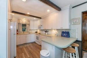 a kitchen with white cabinets and a counter top at Seascape Cottage - Kitty Hawk, MP 3.5, 300 Yds to Beach, Pool, Foosball, Near Golf Course, Flex Stays in Kitty Hawk +38 photos
