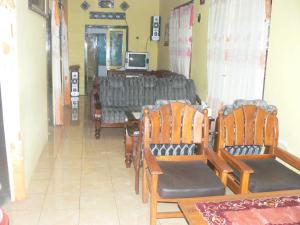 a room with two chairs and a table with a television at Ijen Adventure Inn in Banyuwangi