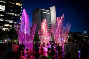 a group of people standing in front of a fountain at night at Luxury Apt W/Parking CityView|Pool| Gym|PoolTable in Dallas +43 photos