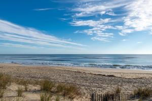 a sandy beach with the ocean in the background at Aqua Moon - Kitty Hawk MP 3, Oceanfront, Family Friendly, Hot Tub in Kitty Hawk