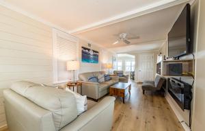 a living room with white furniture and a flat screen tv at Aqua Moon - Kitty Hawk MP 3, Oceanfront, Family Friendly, Hot Tub in Kitty Hawk