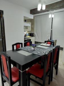 a black table with red chairs in a kitchen at La tranquera ll in Trapiche