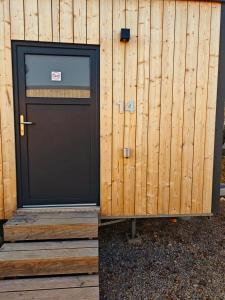 a door on a building with a wooden fence at Tiny Guesthouse Euerbach in Euerbach
