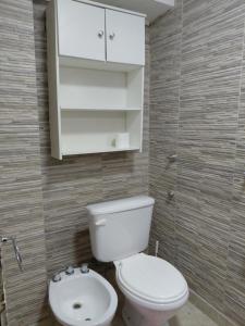 a bathroom with a white toilet and a sink at La tranquera ll in Trapiche +33 photos