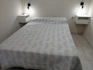 a large bed in a room with two night stands at La tranquera ll in Trapiche