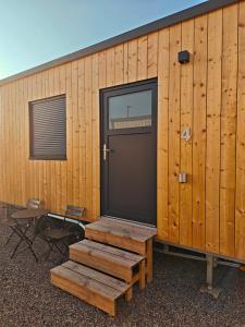 a wooden building with a door and a table and chairs at Tiny Guesthouse Euerbach in Euerbach