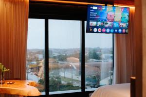 una stanza con una grande finestra con una tv sopra di Catuai Hotel Jaru a Juru