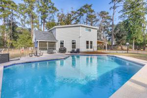 a large swimming pool in front of a house at Riverfront Savannah Getaway w/ Pool & Dock! in Savannah