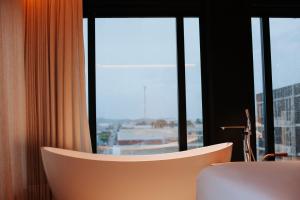 un bagno con una vasca davanti a una finestra di Catuai Hotel Jaru a Juru Altre 25 foto