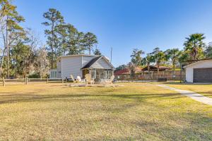 a yard with a house and a table and chairs at Riverfront Savannah Getaway w/ Pool & Dock! in Savannah