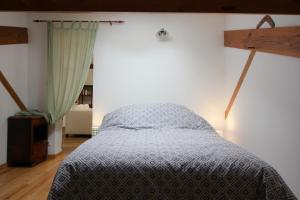 a bedroom with a bed with a blue comforter at Adishatz in Salles