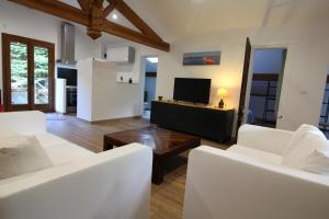 a living room with white chairs and a television at Adishatz in Salles