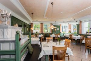 a restaurant with white tables and chairs and windows at Hotel Tenz in Montagna