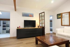 a living room with a flat screen tv and a couch at Adishatz in Salles