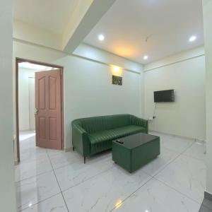 a living room with a green couch and a door at Philip's Signature Suites in Cochin