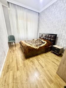 a bedroom with a bed and a chair at Sumgayit Apart House in Sumqayıt