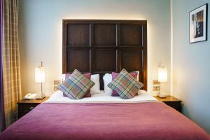 a bedroom with a large bed with two lamps at The Parliament House Hotel in Edinburgh