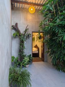 a room with a bed and a hallway with plants at Wild Pulse Yala in Tissamaharama