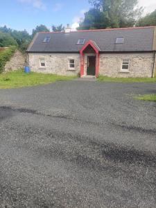 a house with a driveway with a garage at Carrowkeel Cottage in Athlone
