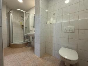 a white bathroom with a toilet and a sink at Groß Genuss in Kaibing +13 photos