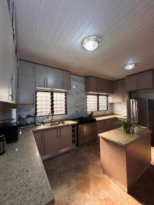 a large kitchen with wooden cabinets and stainless steel appliances at C&B House MV in Accra