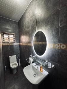 a bathroom with a sink and a mirror and a toilet at C&B House MV in Accra +11 photos