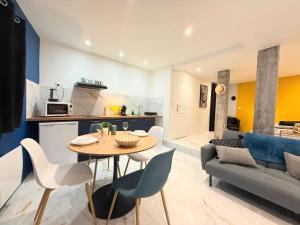 a kitchen and a living room with a table and chairs at Magnifique studio, proche du centre in Rodez