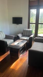 a living room with two couches and a coffee table at Gurugoda Riverside Villa in Ruwanwella +17 photos