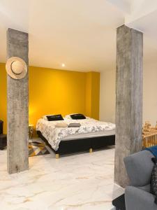 a bedroom with a bed and a yellow wall at Magnifique studio, proche du centre in Rodez