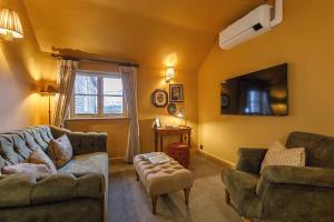 a living room with two couches and a tv at Morston Hall in Holt