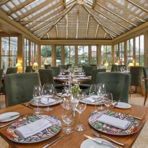 a wooden table with glasses and plates on it at Morston Hall in Holt