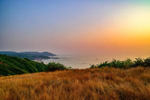 a view of the ocean from a hill at sunset at Tim's Place Anjuna beach in Anjuna