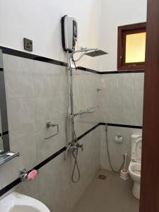 a bathroom with a shower and a toilet in it at Gurugoda Riverside Villa in Ruwanwella