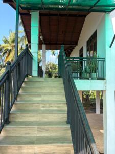 a staircase leading up to a house with a balcony at Gurugoda Riverside Villa in Ruwanwella
