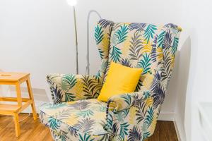 a blue and white chair with a yellow pillow at Flex SelfCheckIns 209 - Zagreb - Studio Apartment - Centre in Zagreb