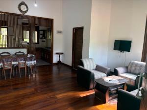 a living room with a couch and chairs and a table at Gurugoda Riverside Villa in Ruwanwella