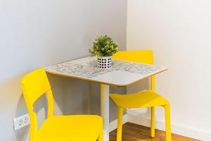 a table with two chairs and a potted plant on it at Flex SelfCheckIns 209 - Zagreb - Studio Apartment - Centre in Zagreb