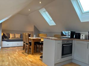 a kitchen and dining room with a table and a couch at Magog View in Sawston