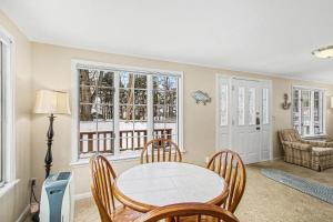 a dining room with a table and chairs and windows at A Shore Thing in Douglas