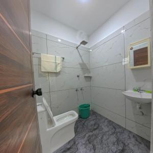 a bathroom with a toilet and a sink at Philip's Signature Suites in Cochin +29 photos